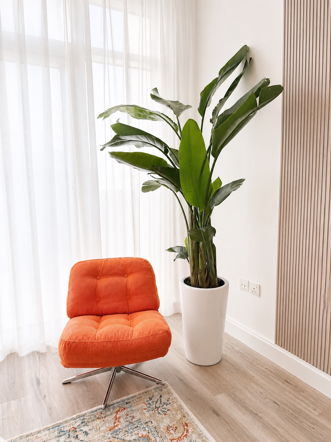 Orange lounge chair beside a tall tropical plant